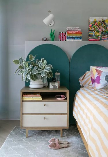 Bedroom with gray walls, teal headboard and orange striped duvet cover