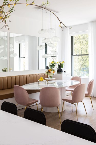 dining room with blush chairs, brown banquette and black bar stools