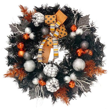 Halloween-themed wreath with black, white, and orange decor