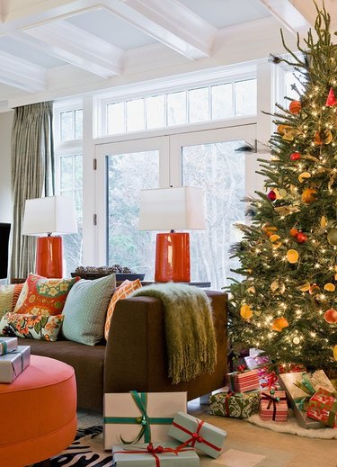 Orange and turquoise living room with Christmas tree with dried citrus on it.