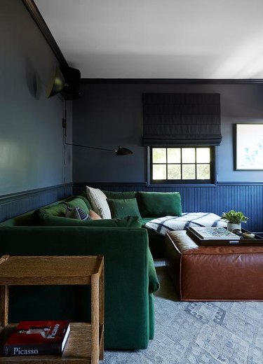 cozy family room with gray walls, green sofa and black and brown accents