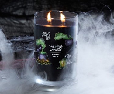Black Yankee Candle called Witches Brew surrounded by spooky smoke