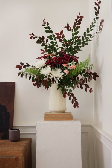 Plinth table with vase, flowers.