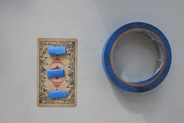 Three pieces of blue painter's tape rolled into strips and attached to back of tarot card