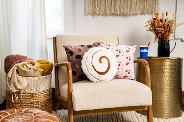 cinnamon roll pillow on ivory accent chair