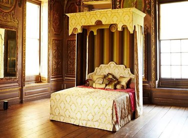 Queen Elizabeth's “Royal State Bed” in a wooden room.