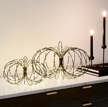 Light up pumpkins made of wire with two candles