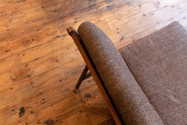 a futon couch with a herringbone pattern on a rustic wood floor