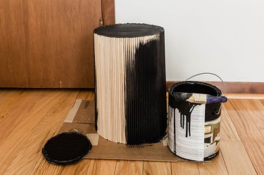Trash can with glued wood dowels and painted with black paint