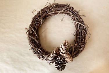 pine cones attached with wire to a grapevine wreath base