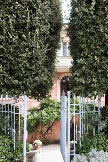 White metal gate opened to a garden