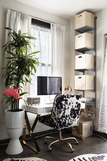 Office corner with white desk and cube shelves, and faux cow hide chair