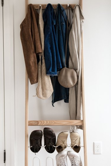 jackets and shoes hanging on a wooden coatrack