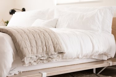 a platform bed made from birch plywood panels with white bedding
