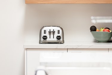 stainless steel toaster on white cabinets