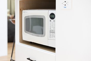 white microwave in white kitchen cabinet