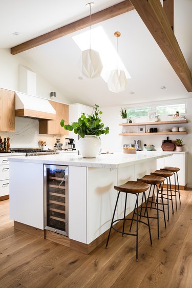 wood beam in white modern kitchen with open shelving and built in wine fridge and skylight