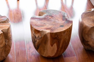 Natural wood drum stools with wood grain on a hardwood floor.