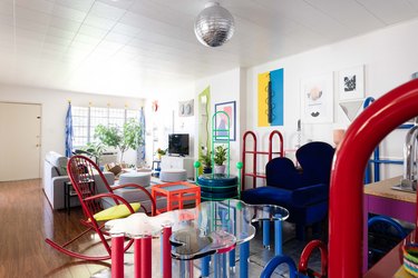 Bold colorful tables, accent chairs, and art with wavy organic shapes.
