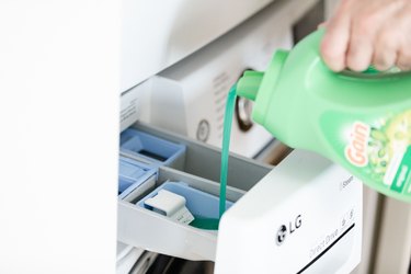 adding laundry detergent to machine