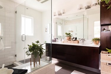 modern double-sink bathroom with glass shower and dark wooden vanity
