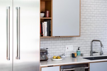 white kitchen with subway tile backsplash and stainless steel appliances