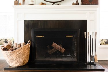 A black gas fireplace with a white mantel