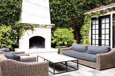 woven outdoor sofas with grey cushions and outdoor fireplace