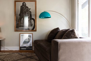blue turquoise arc lamp over grey brown couch