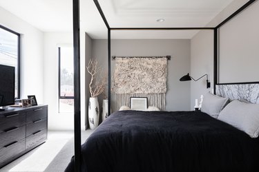 Minimalist bedroom wtih black and white bedding and black furniture