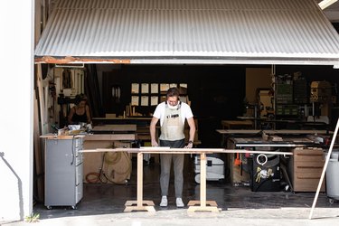 A workshop studio with a person working at a woodworking table