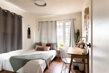 A minimalist bedroom with gray-brown color scheme and wood floors