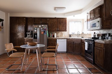 Kitchen with dark brown cabinets, tile floor.