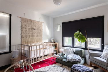 A neutral nursery with a black roller shade