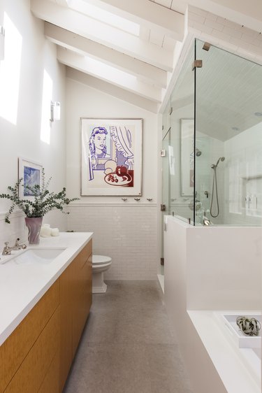 bathroom vanity with single sink, white countertop, and natural wood cabinets