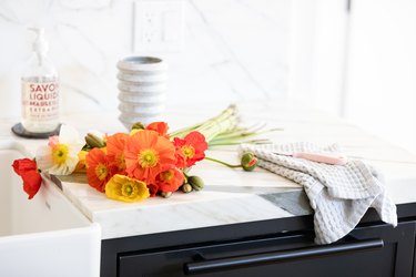 Red and orange flowers on a white countertop with black cabinets
