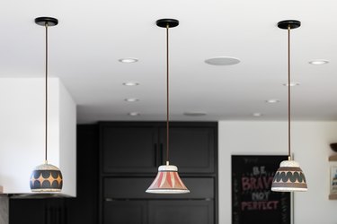 Pendant lights with multi-colored shades in a white-walled kitchen