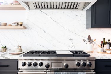 Stove with marble backsplash and vent hood