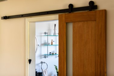 A wood door leading to a bathroom