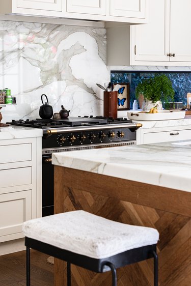 Wood kitchen island, a white-cushioned stool and a white cabinet kitchen