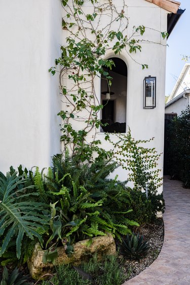 White mediterranean home with terra-cotta roofing and green ivy