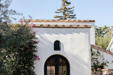 A white Mediterranean style house with terra-cotta roofing and arched windows