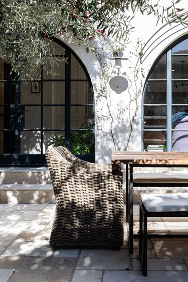 White Mediterranean styled home with large arched windows and patio furniture