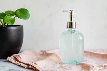 a glass jar with a pump full of diy hand sanitizer