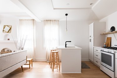 modern white open plan kitchen with white linen voiles