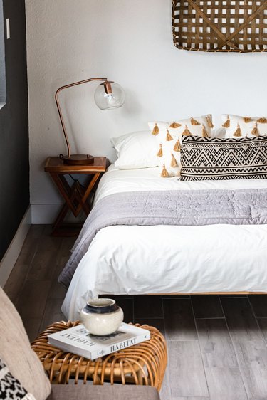 White walled bedroom with gray-neutral accents and wicker decor