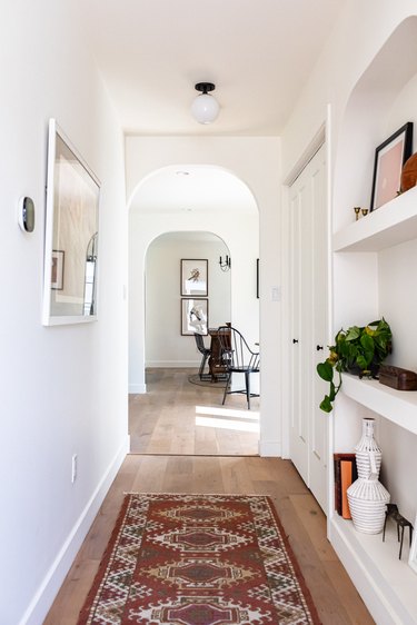 Hallway Lighting Ideas in white hallway with vintage look red rug