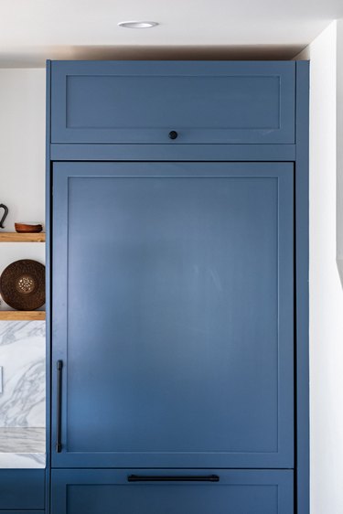 Blue kitchen cabinets with black handles