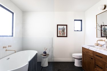 A bathroom with a freestanding tub and a wood vanity