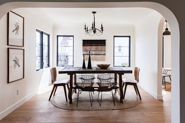 minimalist, neutral dining room with wood table and mixed chairs